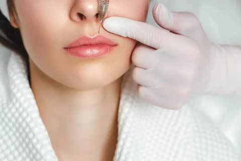 Lip augmentation and correction procedure in a cosmetology salon. The specialist Stock Photos