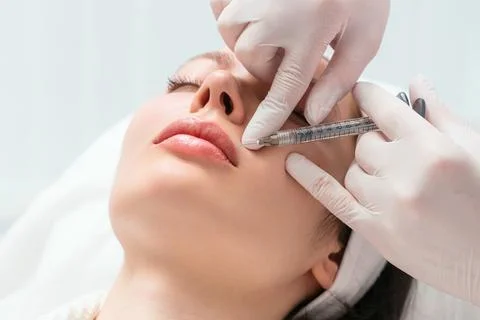 Lip augmentation and correction procedure in a cosmetology salon. The specialist Stock Photos