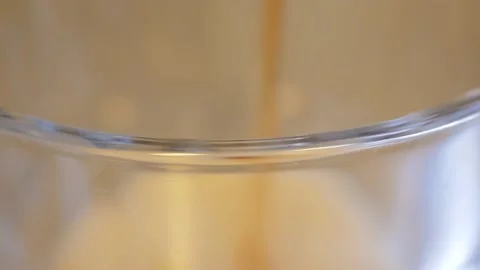 The lip of a large glass in focus as a dark fizzy diet soda is being Stock Footage 154287764