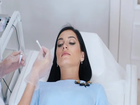 Lip permanent makeup procedure in salon. Doctor puts on the lip anesthesia cream Stock Footage 74522416