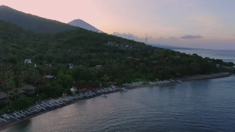 Lipah beach flyover at sunset behind Mount Agung in Amed Bali Stock Footage 224692591