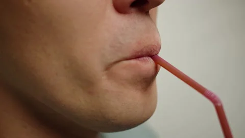 Lips close up of a man drinking a cocktail drink made from plastic tubes Stock Footage 140617838