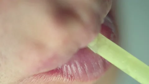 Lips of a man who drinks from a plastic tube, top view, macro shooting Stock Footage 153950570
