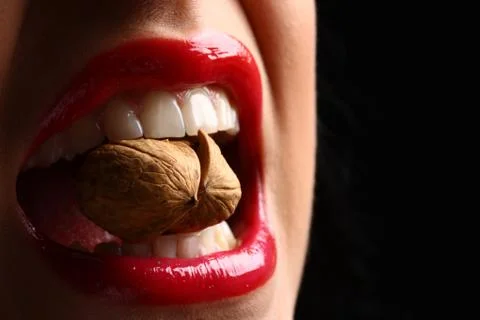 Lips, teeth, nut cracking Stock Photos