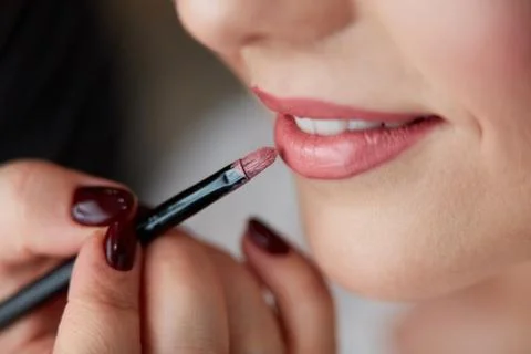 Lipstick is being applied to lips 스톡 사진