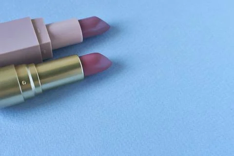 Lipsticks on a blue background with copy space for text. Stock Photos