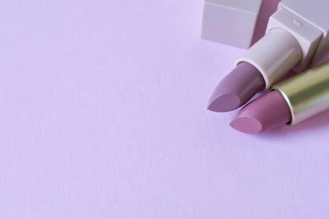 Lipsticks on a lilac background. Stock Photos
