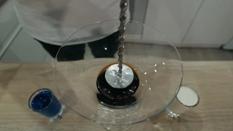 Liqueur flows over long cocktail spoon. Top view, slow motion, close up Stock Footage 134034132