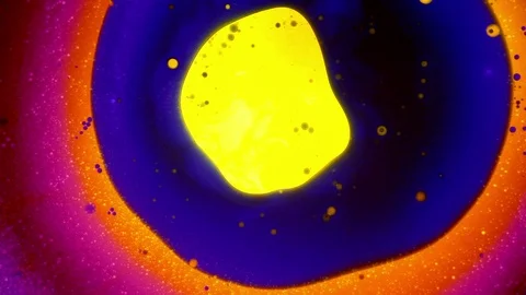 Liquid art yellow spot trying to break trough the circle of blue dye Stock Footage 124288317