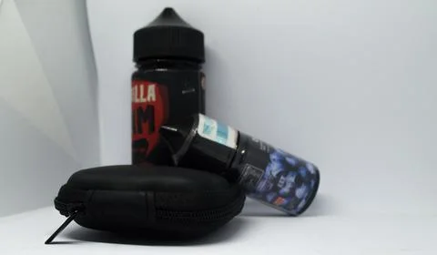Liquid bottles for vaping or e-cigarettes and a small gift box Stock Photos
