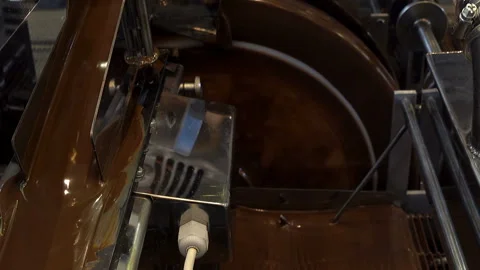 Liquid chocolate is poured in a machine in a factory. Stock Footage 130522191