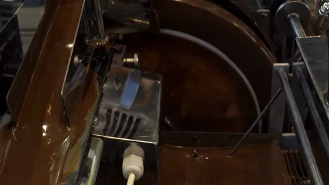 Liquid chocolate is poured in a machine in a factory. Stock Footage 133344209