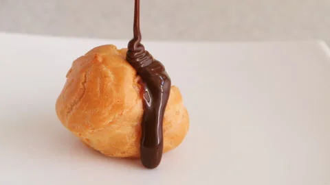 Liquid chocolate is poured on a round bun cake.Window Reflection Stock Footage 155349800