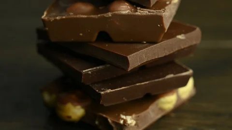 Liquid chocolate pours onto different chocolate bars Video stock 126765158