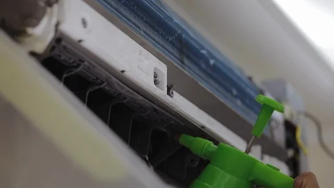 Liquid detergent is sprayed in the radiator of a home air conditioner Stock Footage 122085540