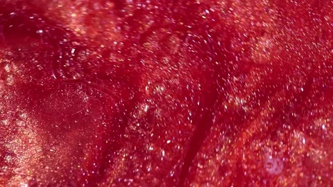 Liquid with dissolved particles of red candurin and bubbles slowly moves and shi Video stock 306073910