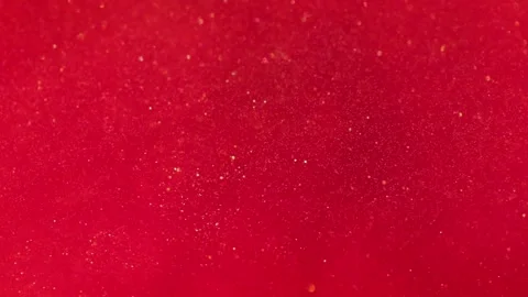Liquid with dissolved particles of red candurin and bubbles slowly moves and shi Stock Footage 306074207