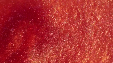 Liquid with dissolved particles of red orange candurin and bubbles slowly moves  Stock Footage 306074067