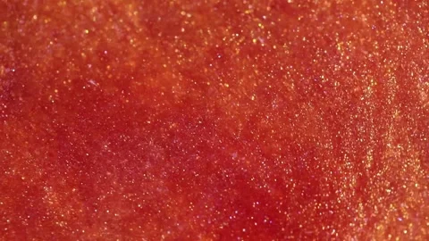 Liquid with dissolved particles of red orange candurin and bubbles slowly moves  Video stock 306074102