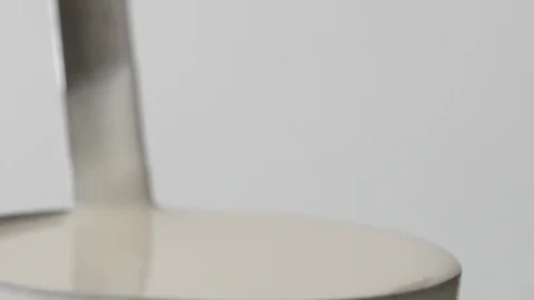 Liquid dough for pancakes flows down from the ladle in slow motion Stock Footage 94122993