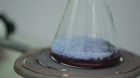 Liquid Dripping From Test-Tube Into Flask Stock Footage