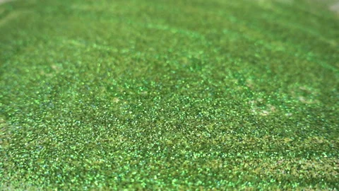 A liquid drips onto the surface consisting of green spangles in the slow motion. Stock Footage 110917724