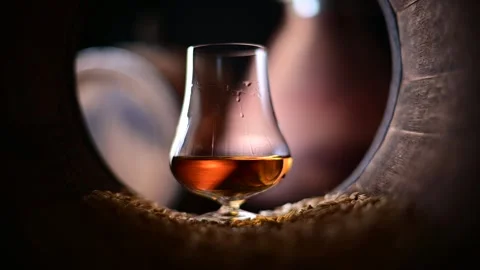 Liquid droplets cascade down the side of a glass whiskey Stock Footage 270985631