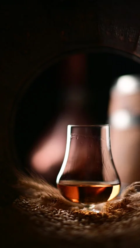 Liquid droplets cascade down the side of a glass whiskey Stock Footage 270985999