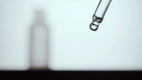 Liquid dropper or pipette. Fluid drop falling. White background Vídeo Stock 120436182