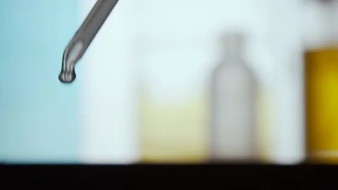 Liquid dropper, pipette. Fluid drop falling. Blue and yellow background Vidéo 120687831