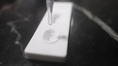 Liquid Dropping on Covid Rapid Test for Infection Diagnosis Close Up Stock Footage 335426159
