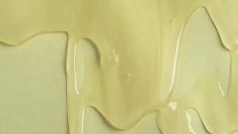 Liquid drops of yellow paint cosmetics product flowing on the yellow surfac.. Stock Footage 252487967