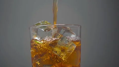 Liquid Falling into a Glass with Ice Stock Footage 293415391