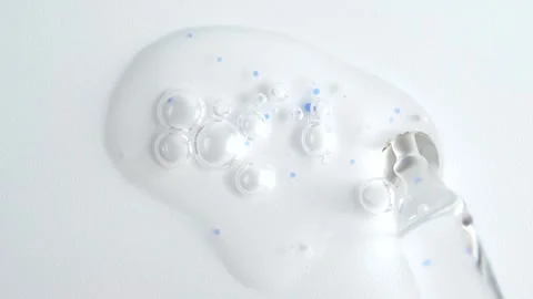 Liquid fluid transparent gel or serum with blue granules in pipette drips o.. Stock Footage 259031547