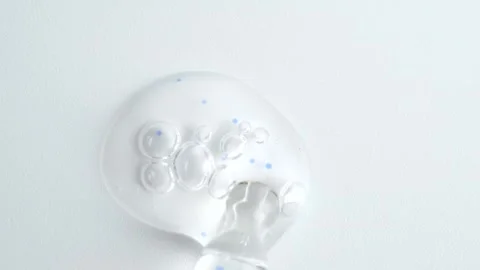 Liquid fluid transparent gel or serum with blue granules in pipette drips o.. Stock Footage 260245991