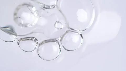 Liquid fluid transparent gel or serum in pipette drips on a white surface. .. Stock Footage 274547557