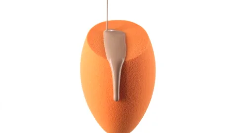 Liquid foundation pour on yellow make up blender sponge for apply on face 動画素材 138371559
