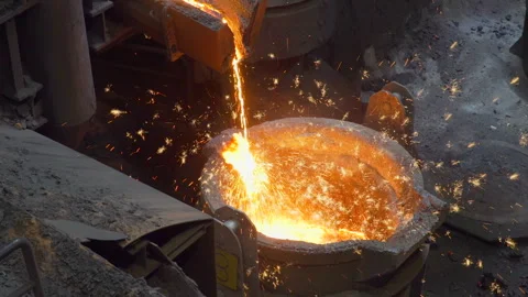 Liquid hot iron cast flowing in a cauldron making sparkles Stock Footage 249620921