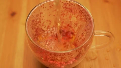 Liquid Jet Falls Into Transparent Glitter Cup, Close-up. The Process of Pouring  Video stock 166092499