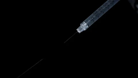 Liquid medicine being sprayed out of an syringe Video stock 81230358
