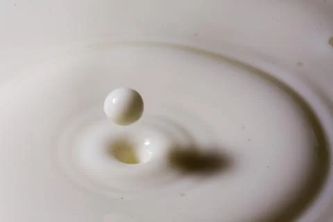 Liquid milk drop falling Stock-Fotos