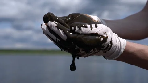 Liquid mud flows into the hands of man Stock Footage