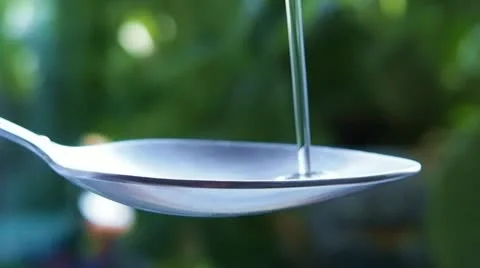Liquid (oil) flowing into the spoon Stock Footage 22201824