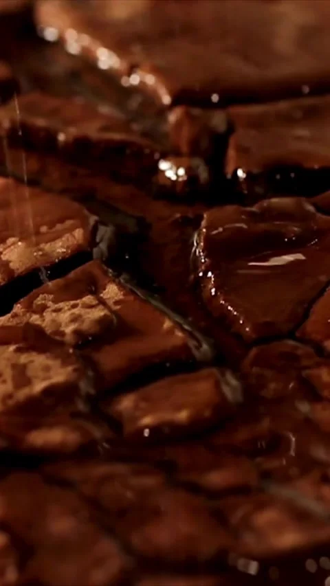 Liquid pouring over broken dark chocolate pieces in macro 스톡 동영상 334169109