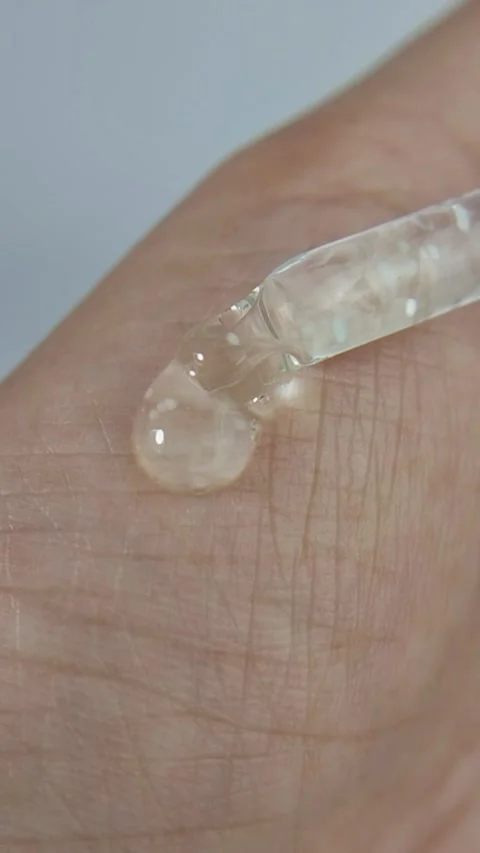 Liquid serum dripping onto the hand. Close up view for the concept of beauty. Vídeos de archivo 329876266