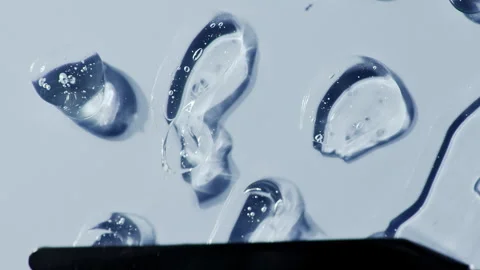 Liquid serum gel on blue background, cosmetic texture with bubble. Video stock 328984459