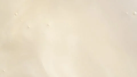 Liquid shiny light beige cosmetics product with bubbles, macro, top view.  .. Stock Footage 251712902