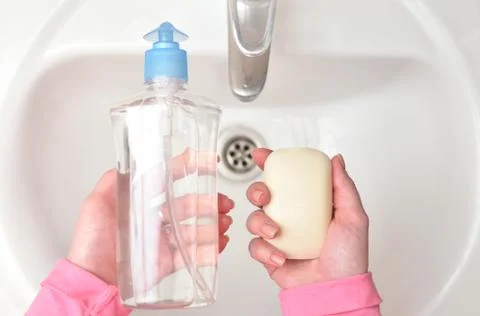 Liquid soap and solid soap in the hands of a girl. The concept of choice Stock Photos