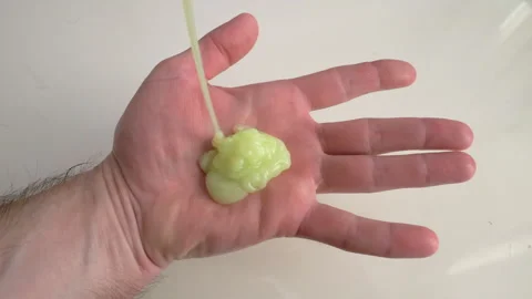 Liquid soap flows onto the palm of man's hand, green liquid paint Stock Footage 336557119