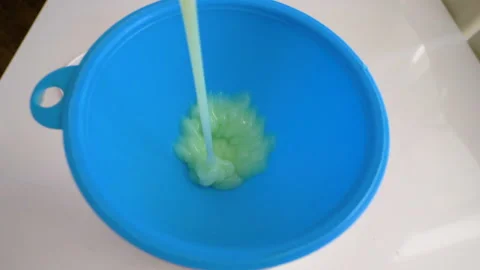 Liquid soap is poured into a jar through a plastic watering can Stock Footage 336557106